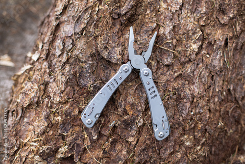 multitool in the forest, on a tree trunk