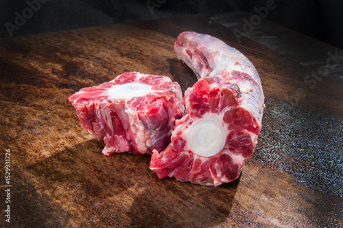 Photos Fresh oxtail on dark background: raw meat cuts.