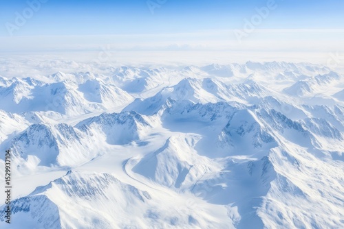 An aerial perspective captures vast mountainous landscapes adorned with glaciation, highlighting stunning snow-covered peaks and serene valleys