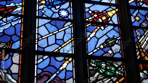 Colorful stained glass windows displaying scenic biblical imagery in church setting