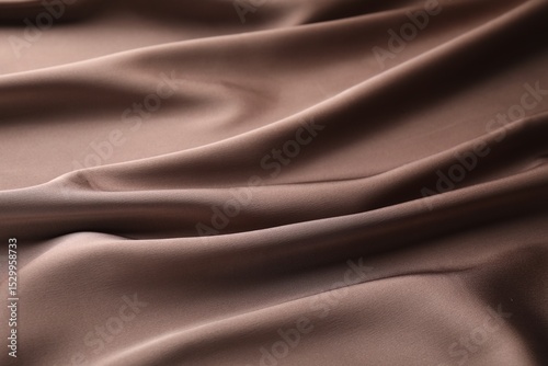 Crumpled light brown silk fabric as background, closeup