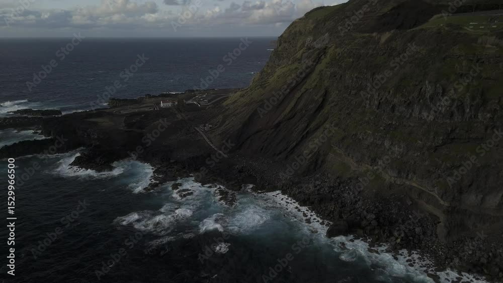 Drone descends on thermal baths by the ocean at Ponta da Ferraria in Sete Cidades region, Sao Miguel, Azores, Portugal