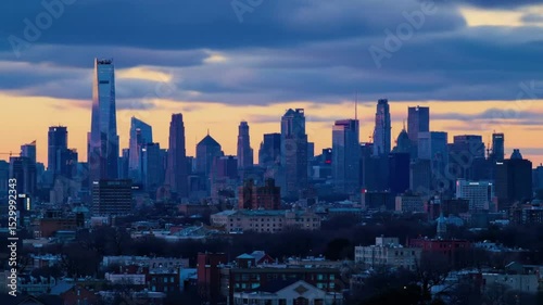Time-lapse of city skyline during sunset, lights turning on in buildings