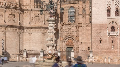 Seville Cathedral entrance and Fuente Farola fountain on Plaza de Virgen de los Reyes city square timelapse. Walking place in downtown with historic architecture. Seville, Andalusia, Spain.