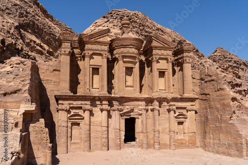 Ancient Wonder: A majestic monument carved into the face of a sandstone cliff, bathed in warm sunlight, standing as a testament to the ingenuity and artistry of an ancient civilization.