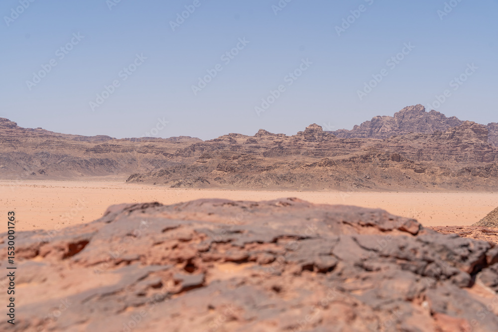 Naklejka premium Desert Landscape: A breathtaking vista of the vast desert landscape, the rough-hewn terrain and textured foreground details the earth's raw beauty and strength.