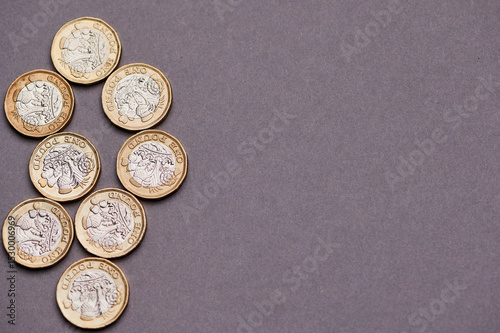 one pound notes arranged neatly on a gray background.