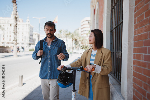 Man and woman in town with e scooter, exploring new town
