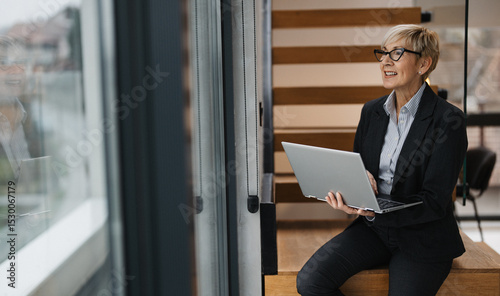 Middle age businesswoman working on laptop in office