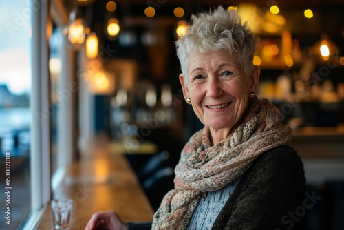Portrait of smiling senior woman sitting at the bar counter in restaurant