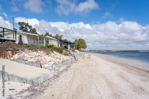 Coastal shacks, beach, and calm water at Black Point, South Australia.