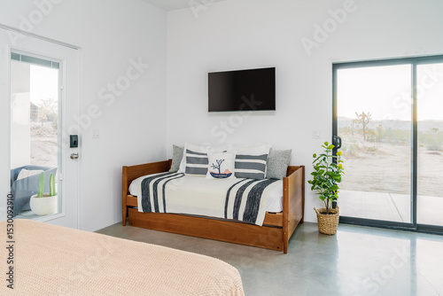 Modern desert interior with daybed, flat screen TV, concrete floors