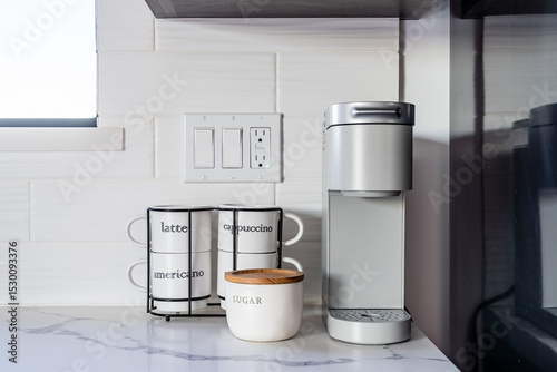 Pod single serve coffee maker with white cups and sugar in kitchen