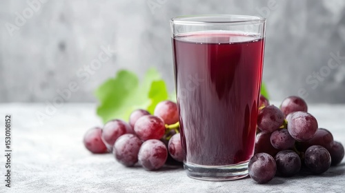 Wallpaper Mural Refreshing natural grape juice in a tall glass with fresh purple grapes scattered on a textured light gray surface and a plain gray background for healthy drink Torontodigital.ca