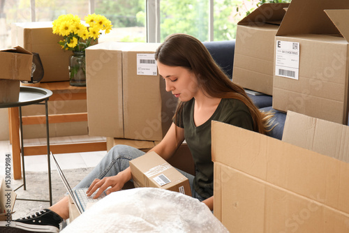 Young woman with parcel usi...