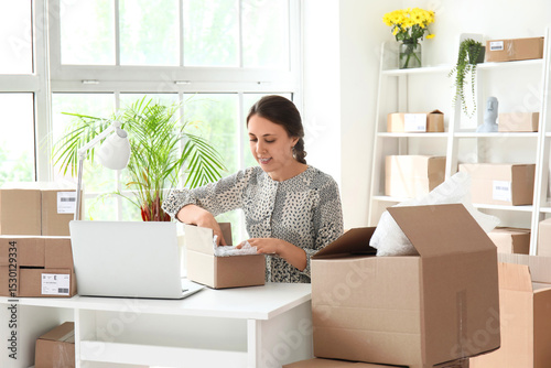 Young woman packing parcel ...