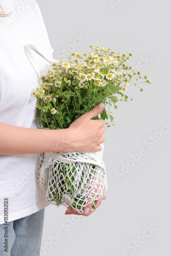 Woman holding mesh bag with...