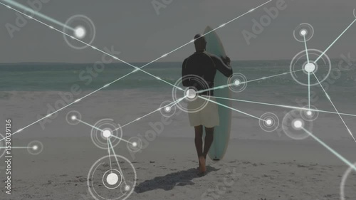 surfboard-toting surfer walking to ocean entering water initiating technology overlay mapping data