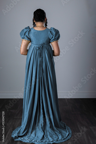 A Regency woman wearing an evening dress with gloves