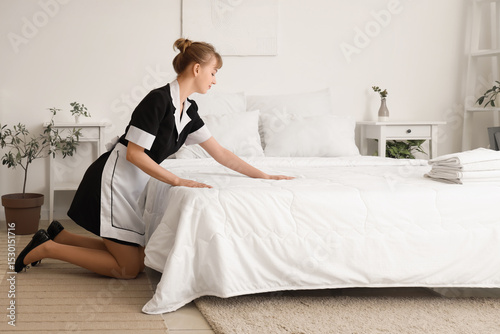 Pretty chambermaid making b...