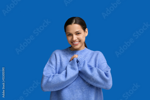 Beautiful young happy woman laughing on blue background