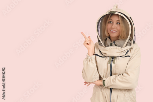 Female beekeeper pointing a...