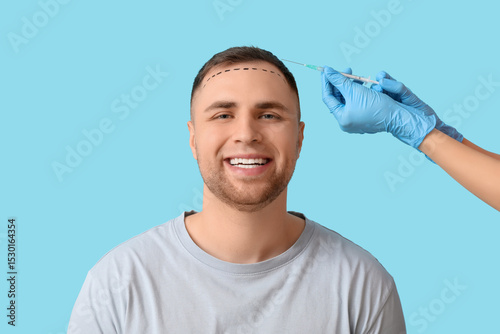Photography Young man with hair loss problem and marks receiving injection on blue backgroun