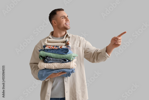 Young man with stack of clo...