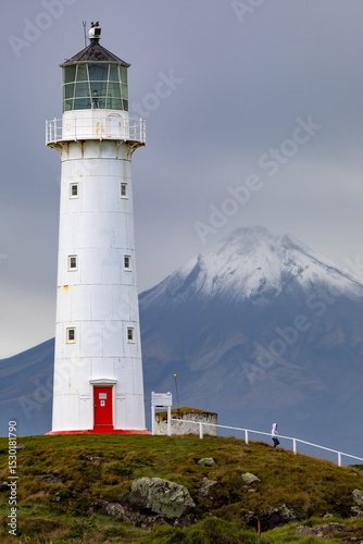 Cape Egmont Lighthouse stands tall on the coast of Pungarehu, Taranaki, New Zealand, guiding ships safely. The iconic landmark is set against the backdrop of Mount Taranaki.