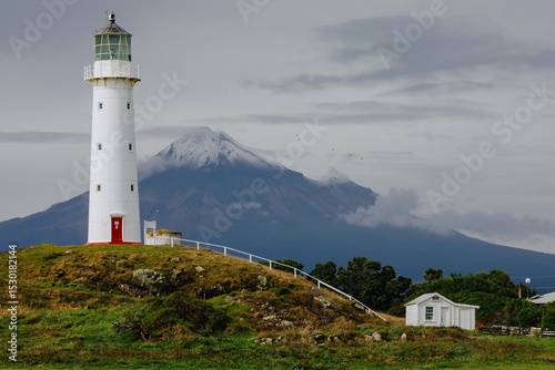 Cape Egmont Lighthouse stands tall on the coast of Pungarehu, Taranaki, New Zealand, guiding ships safely. The iconic landmark is set against the backdrop of Mount Taranaki.