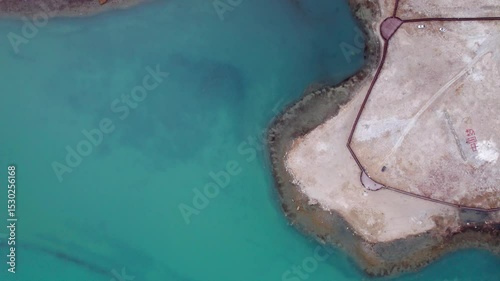 Drone view of Karakul Lake‌ on sunny cloudy day in Tashkurgan County, Kashgar, Southern Xinjiang, China. Aerial landscape of landmark on Pamir plateau, Chinese on beach means 