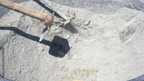 Mixing cement and water with a hoe in a tub for construction work.