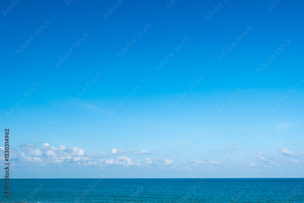 Obraz premium Nature of the ocean and blue sky Summer with sunshine, sandy beaches, clear blue waters sparkling against the blue sky. on an island with good ecology and environment Background for summer vacation 