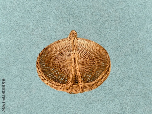 The light green background in the picture is a light-weight, finely woven brown rattan basket with a handle for carrying. It is a colorful household item that is convenient Beautiful colors.
