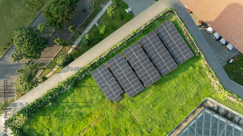 Aerial View of Green Rooftop Solar Panels Installation on Eco-Friendly Building with Lush Landscaping