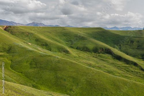 mountain landscape with green grass and clouds