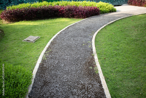 Walkway and landscape in garden, park. Also called path, footpath, pathway or asphalt floor. Include pit cover, natural plant, bush, lawn and grass. Landscaping decoration of outdoor.