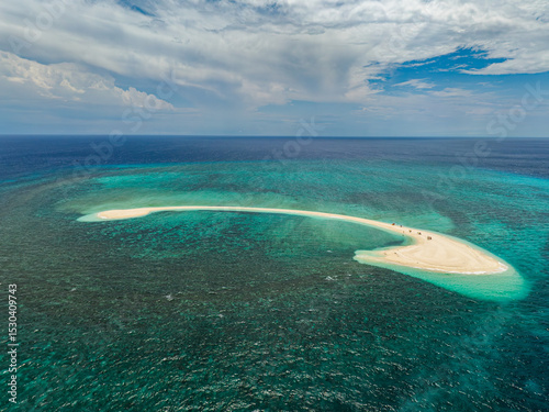 White island surrounded by azure sea water texture. Waves and corals reefs. Camiguin, Philippines.