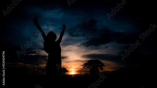 Silhouette of a person with outstretched arms at sunset.