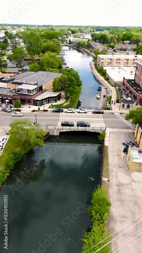 Aerial Flyover Of A Small Lake Town With Riverside Businesses On A Sunny Day