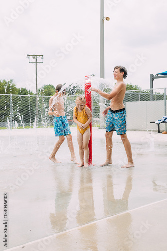 Energetic kids playing together at urban splash pad