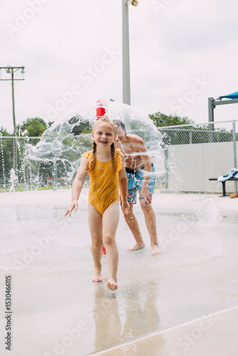 Spirited children playing in city splash pad during summertime