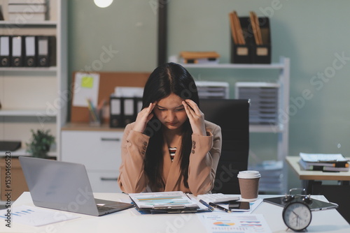 Asian women are stressed while working on laptop, Tired asian businesswoman with headache at office, feeling sick at work, copy space