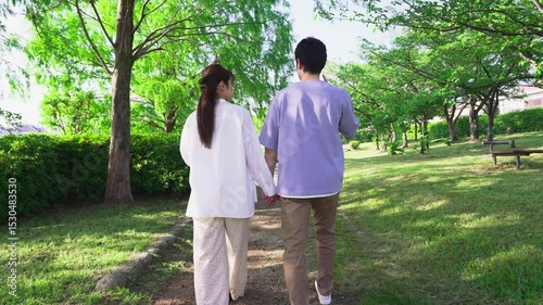 手を繋いで歩く男女の後ろ姿
