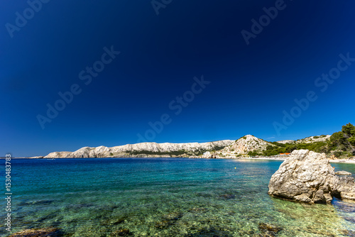 Fototapeta Naklejka Na Ścianę i Meble -  Jablanova Beach on the island of KRK in Croatia, blue trail leading to an empty pebble beach,