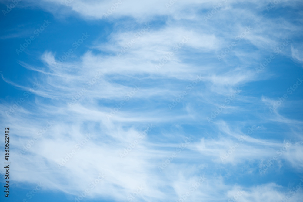 Obraz premium Soft white cirrus clouds against the blue sky on a sunny day. Empty space use for background or backdrop in nature concept