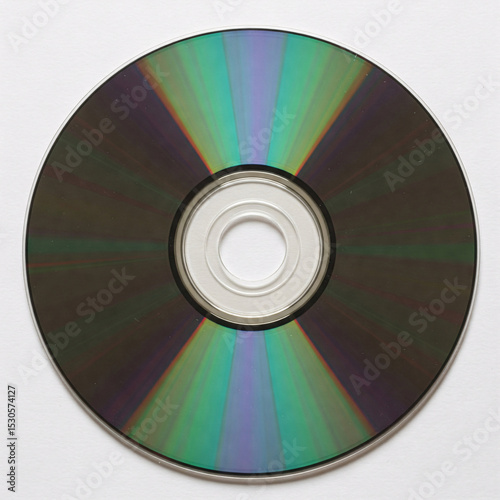 A shiny compact disc with iridescent reflections, catching the light,