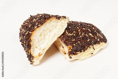 Milk bread with a soft white interior, topped generously with chocolate sprinkles and a touch of white topping. Photographed against a clean white background.