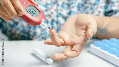 Blood glucose meter diabetes test finger prick elderly hand medical device healthcare monitoring close up chronic illness self care. An elderly person checks blood sugar level home showing self.