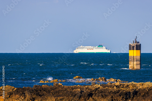 Ferry sailing on the horizon off the coast of Normandy, France